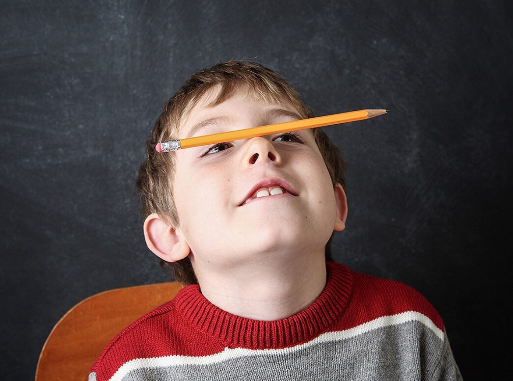 ילד מחזיק על אפו עפרון